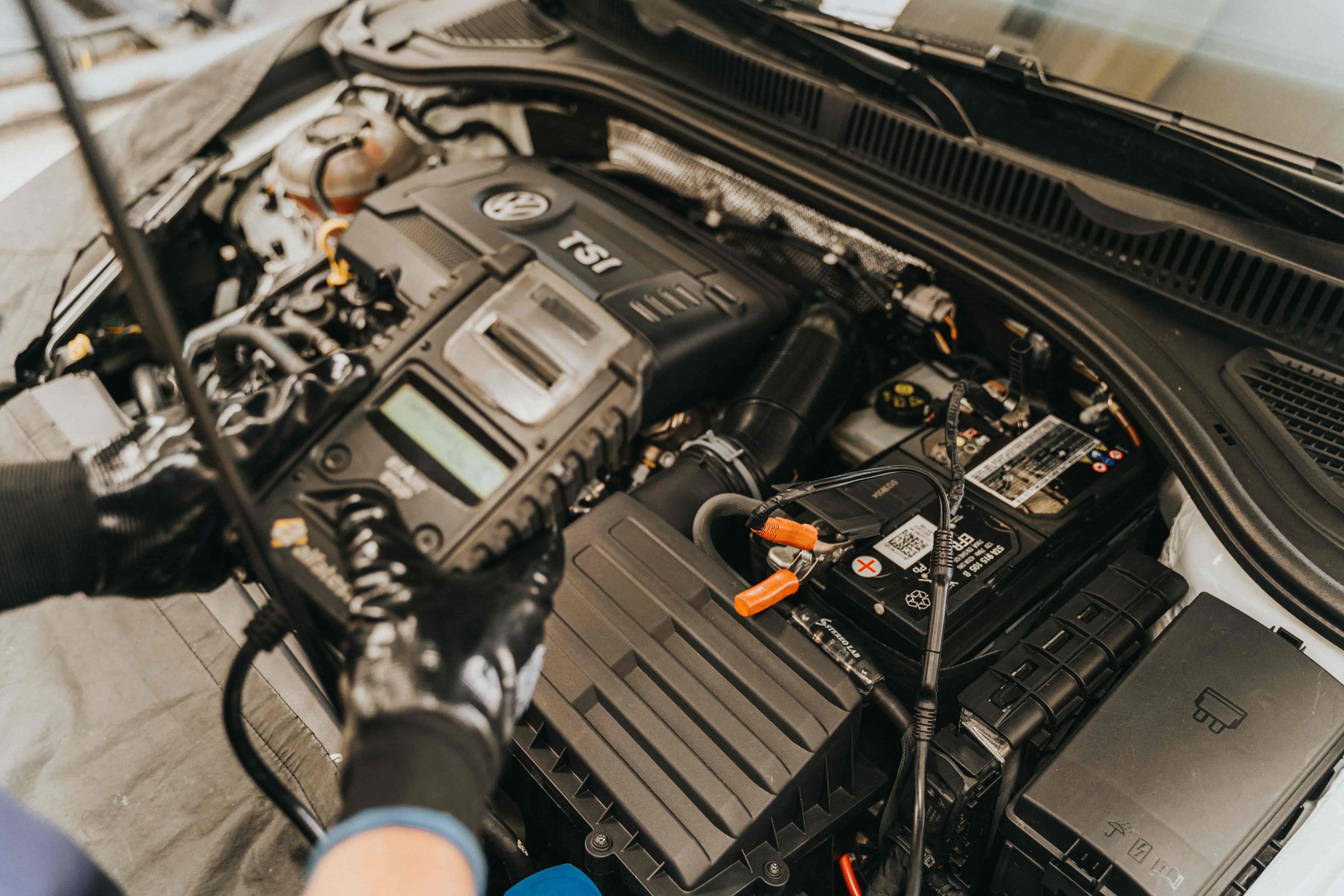 Mechanic using a diagnostic scan tool connected to a car